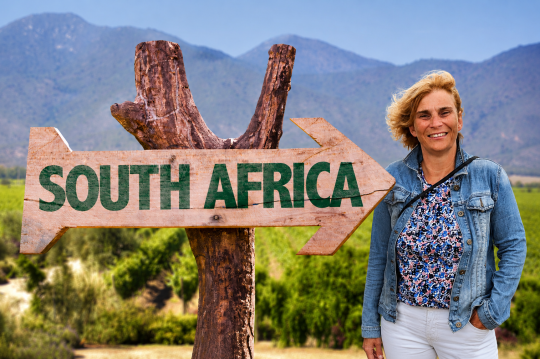 Ein Schild Wegweiser S&uuml;dafrika, daneben eine Frau